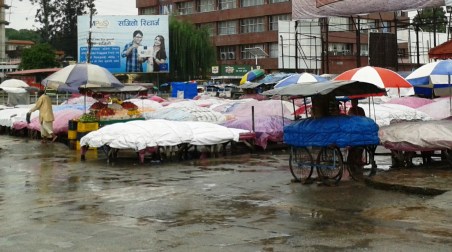 A lone fruit vendor longing for some customers on this rainy morning